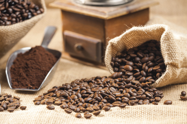 naturaleza muerta de los granos de café en bolsas de yute con molinillo de café
 - Foto, Imagen
