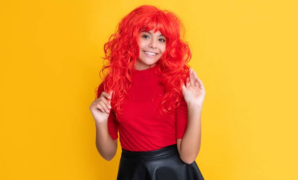 positive teen child with red long hair on yellow background. - Foto, imagen