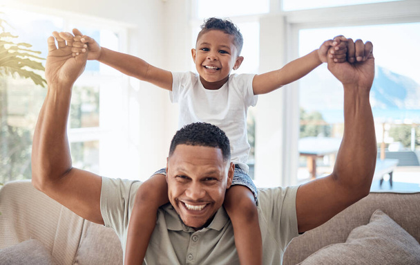 Portrait, father and son on shoulder, smile and happy being loving, bonding and playful together in lounge. Love, black dad and boy child with happiness, spend quality time and joyful in living room - 写真・画像