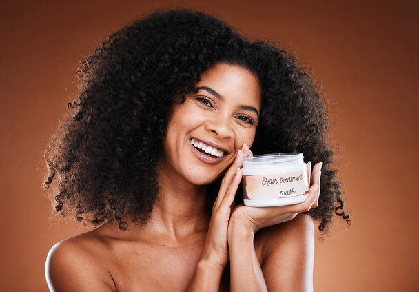 Hair, beauty and black woman with treatment for portrait aesthetic health and wellness on a brown studio background. Hairstyle, cream and moisturiser with an african american female for cosmetics. - Foto, Bild