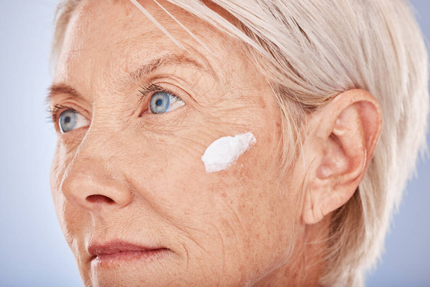 Skincare, beauty and old woman with facial cream in studio posing for face and body care. Wellness, healthcare and senior female with sunscreen, lotion and antiaging skincare products for dermatology. - Photo, Image