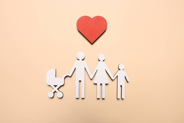 Figures of family and heart on beige background, top view. Insurance concept - Φωτογραφία, εικόνα