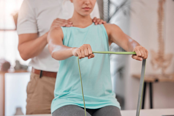 Hands, physiotherapy and rehabilitation with a woman stretching a resistance band in a session at a clinic. Fitness, consultant and rehab with a female patient and physio in an office for recovery. - Photo, Image