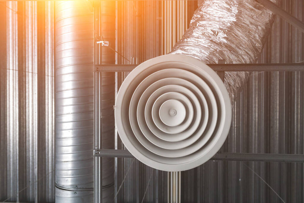Ventilatie- en airconditioningsysteem aan het plafond van een industrieel gebouw, metalen ventilatiepijpen - Foto, afbeelding
