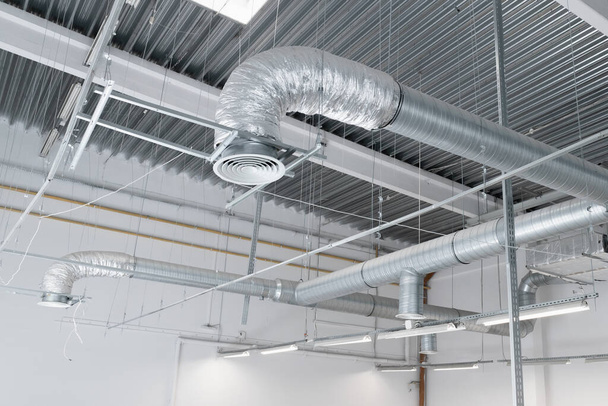 Система вентиляції та кондиціонування на стелі промислового будинку, металеві вентиляційні труби
 - Фото, зображення