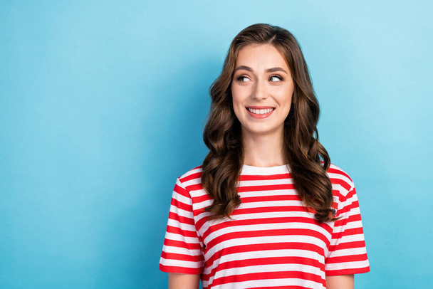 Closeup photo of young attractive adorable nice lady curly hair after salon wear red striped t-shirt looking empty space offer isolated on blue color background. - Foto, Imagen