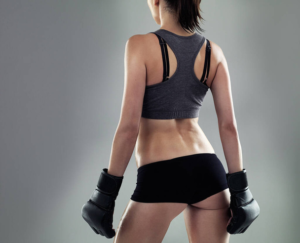 Fitness belichaamd. Studio shot van een sportieve jonge vrouw tegen een grijze achtergrond - Foto, afbeelding