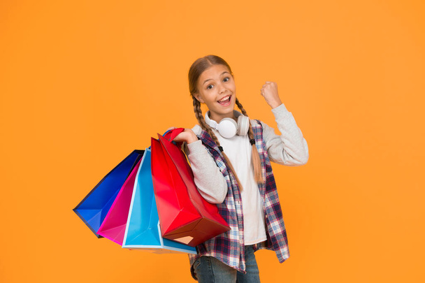 Best outfit ever. holiday gifts in packages. cyber monday. hurry up its total sale. Kids fashion. Sales and discounts. happy small girl after successful shopping. adorable child with heavy bags. - Foto, afbeelding