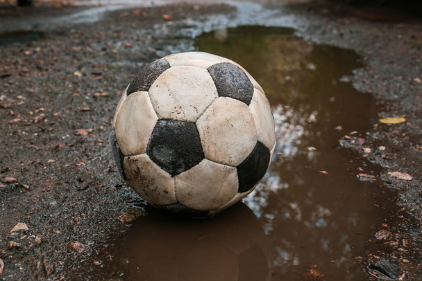 Dirty soccer ball in muddy puddle outdoors - Valokuva, kuva