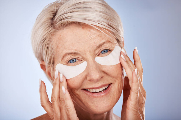 Senior woman with collagen eyes mask for skincare, dermatology and facial wellness on studio mockup marketing or advertising space. Elderly model portrait and eye patches product for antiaging beauty. - Foto, Imagen