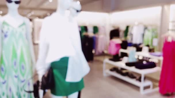 Moda, perakende ve dükkan. Lüks alışveriş merkezindeki giyim mağazasının iç görünüşü bulanık. Yüksek kalite 4k görüntü - Video, Çekim