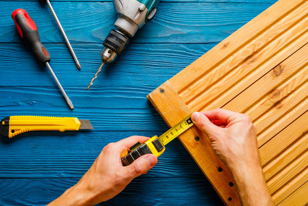 Handyman in blue uniform works with electricity automatic screwdriver. House renovation conception. - Fotografie, Obrázek