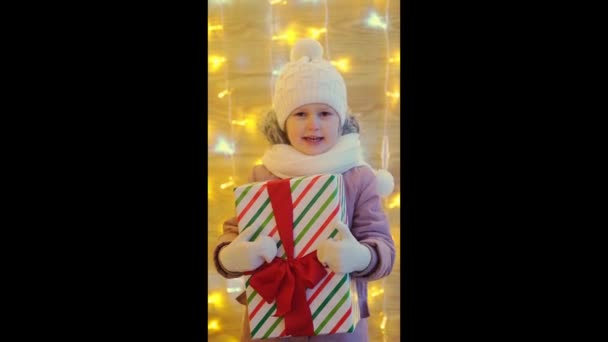Felice bambina con regalo di Natale scatola in inverno all'aperto la vigilia di Natale. Regali di Natale Vacanze concetto di infanzia - Filmati, video