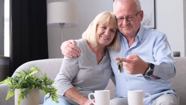 I pensionati americani felici hanno comprato una nuova casa, hanno le chiavi in mano. Nonno e nonna insieme in una nuova casa - Filmati, video