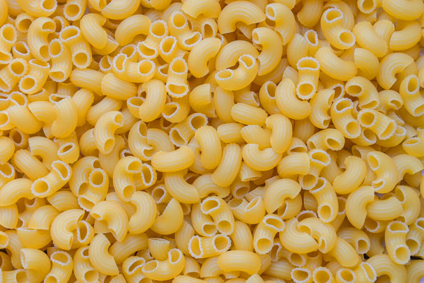 Pasta achtergrond - bovenaanzicht, ruwe macaroni textuur achtergrond, close-up rauwe macaroni pasta ongekookte heerlijke pasta voor het koken van voedsel - Foto, afbeelding