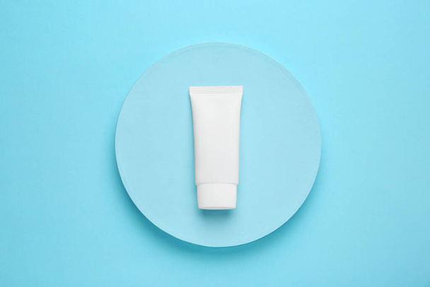 Tube of hand cream on turquoise background, top view - Zdjęcie, obraz