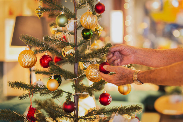 Senior schmückt zu Hause einen Weihnachtsbaum - Foto, Bild