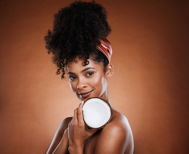 Woman, coconut fruit and body skincare glow on studio background for organic hydration, vegan moisture or holistic dermatology. Portrait, smile and happy african beauty model with coco butter product. - Фото, изображение