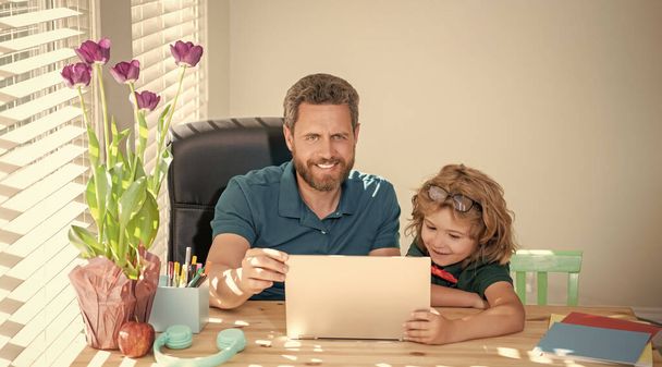 fröhlicher Vater und Sohn in der Schule arbeiten online am Laptop, Wissen. - Foto, Bild