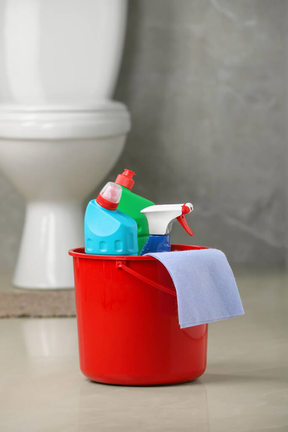 Bucket with cleaning supplies on floor in bathroom - Photo, Image