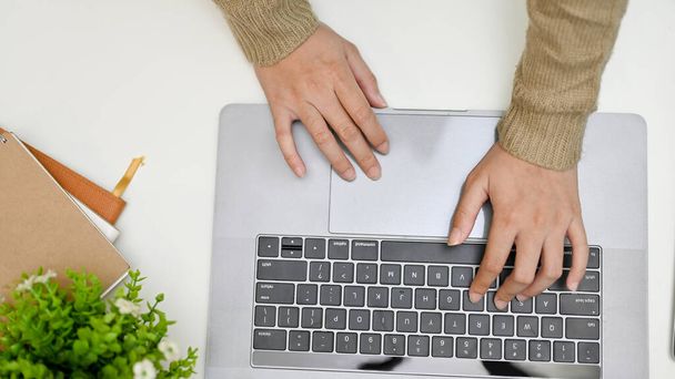 Top view, Feminino em camisola aconchegante trabalhando em sua mesa moderna mínima, usando computador portátil, mãos digitando no teclado notebook. - Foto, Imagem