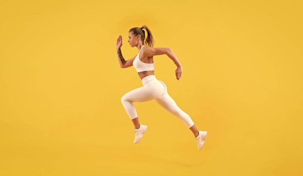 corredor de fitness mujer corriendo sobre fondo amarillo. - Foto, imagen