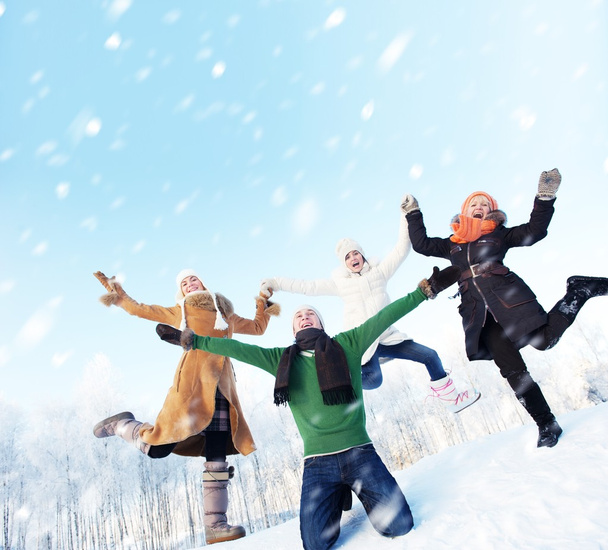 Happy friends jumping in the snow - Foto, imagen