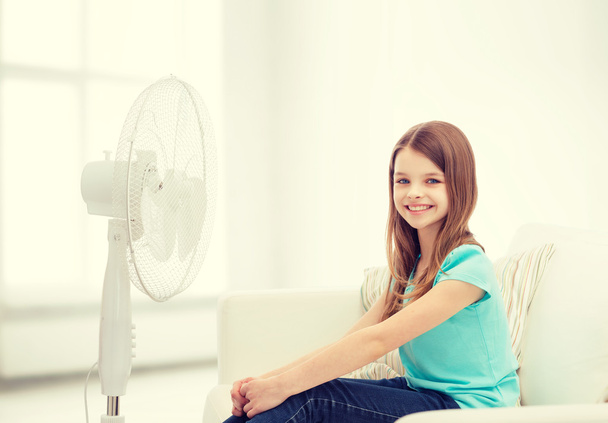 smiling little girl with big fan at home - Фото, зображення