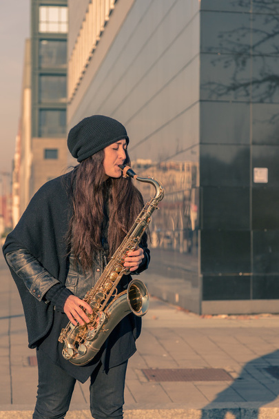 Beautiful young woman playing tenor saxophone - Photo, image