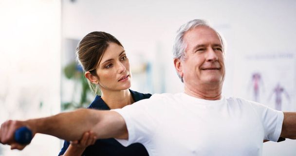 Fyzikální terapie, cvičení a fyzioterapeut se starším mužem, který mu pomáhá uzdravit se na rehabilitační klinice. Zdravotnictví, wellness a starší člověk dělá cvičení s tělesnou hmotností ve třídě fyzioterapie - Fotografie, Obrázek