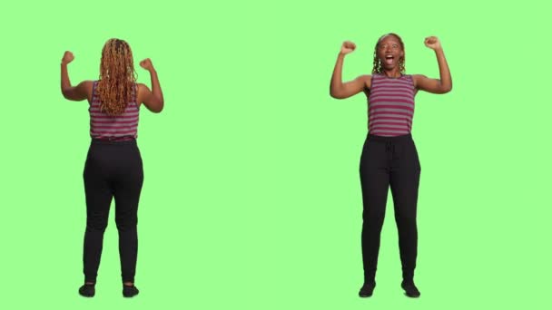 Smiling lovely girl being optimistic over green screen backdrop, full body on greenscreen. Positive woman cheering and supporting, being joyful and confident on studio background. - Footage, Video