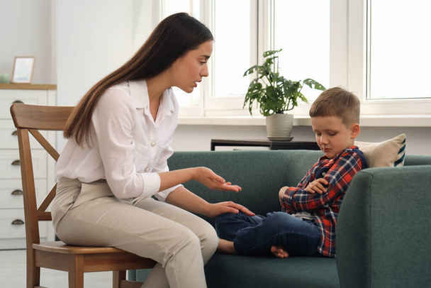 Psychologist working with unhappy little boy in office. Mental health problems - Zdjęcie, obraz
