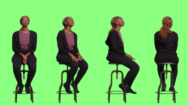 Alkalmi személy ül a széken négy oldalon át teljes test zöld háttér, vár a sorban, és felkészülés. Nyugodt nő ül felkészülés felett zöld képernyő háttér. - Felvétel, videó