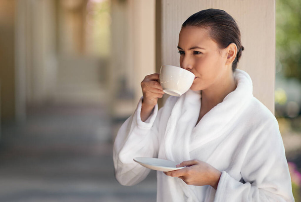Feeling serene in the silence. a young woman drinking a cup of coffee at the day spa - Zdjęcie, obraz
