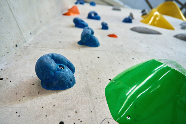 Wall for bouldering in gym with holds for climbing. Active extreme sport concept - Photo, image