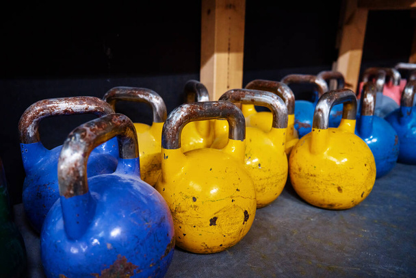 Row of colorful kettlebells in gym. Equipment for sport exercises. Sport activity and healthy lifestyle concept - Photo, Image