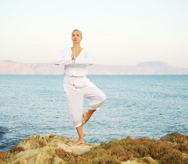 Belle jeune femme faisant de l'exercice de yoga en plein air - Photo, image