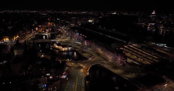 Amsterdam keskustan taivaanrantaan yöllä antenni yläpuolella näkymä. Amsterdam Centraal, Ij, Prins Hendrikkade, julkinen liikenne, liikenne yöllä. Kirkkaat valot kaupunkien - Materiaali, video