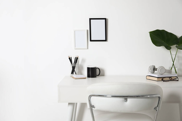 Comfortable workplace with white desk near wall at home - Photo, Image