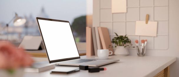 Рабочее пространство рабочего стола женщины на фоне окна с макетом белого экрана ноутбука, губной помадой, канцелярскими принадлежностями и декором. 3D рендеринг, 3D иллюстрация - Фото, изображение