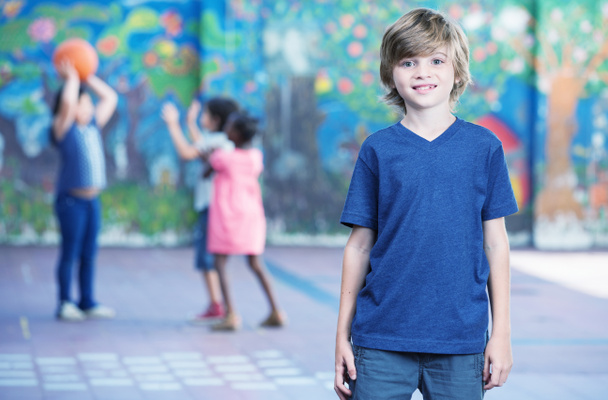 Niño feliz sonriendo en el patio de la escuela con otros niños jugando en
  - Foto, Imagen
