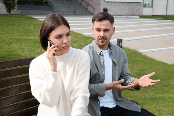 Woman ignoring her boyfriend and talking on phone. Relationship problems - Φωτογραφία, εικόνα