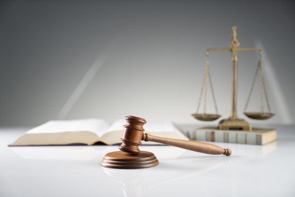 Концепция закона и справедливости. Судейский молоток и юридический код на белом столе. - Фото, изображение