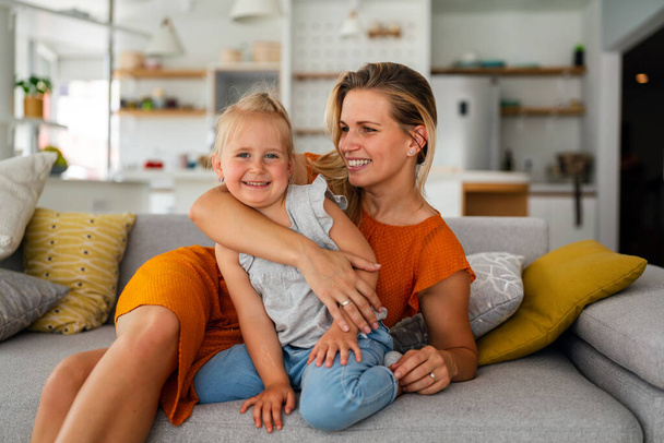 Happy loving family. Young mother and her daughter child girl playing and hugging together at home - Valokuva, kuva
