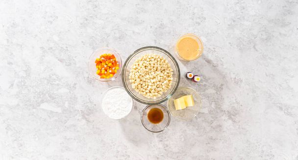 Flat lay. Measured ingredients in glass mixing bowls to make candy corn fudge. - Фото, зображення