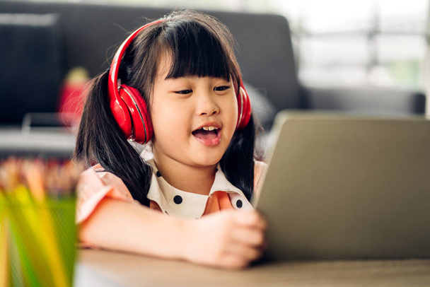 学校の子供の小さな学生の女の子は、学習し、オンライン教育eラーニングシステムで知識を勉強宿題を作るラップトップコンピュータを見て. - 写真・画像
