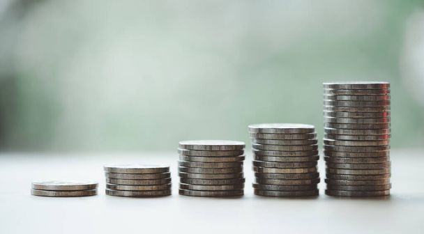 Cash flow growth from long-term sustainable investments, financial concept. Five increasing-height coin stacks with a green bokeh background, depicting saving money for retirement. - Photo, image