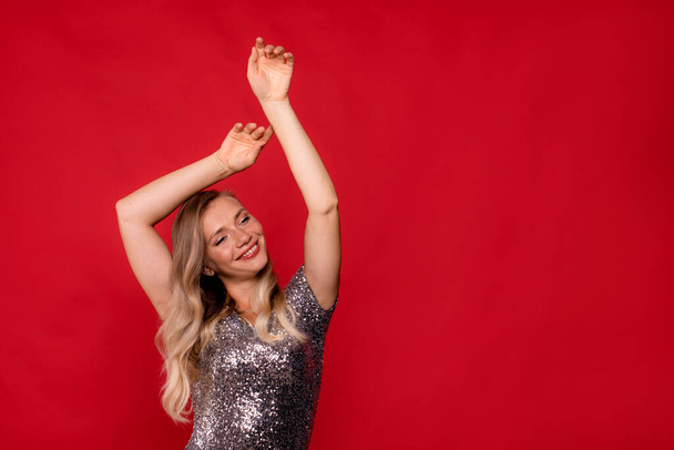 dancing woman on red background. concept advertising joy, improvement, victory, new year, events in life - 写真・画像