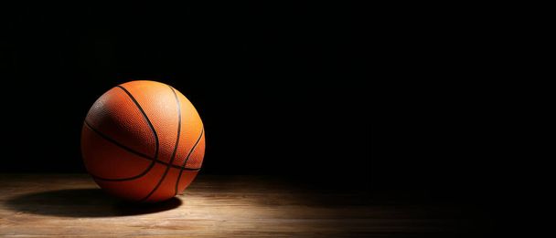 テキストのためのスペースと暗い背景にバスケットボールをプレイするためのボール - 写真・画像