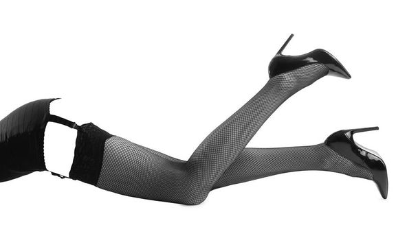 Jambes de belle femme en bas noirs et chaussures à talons hauts isolés sur blanc - Photo, image